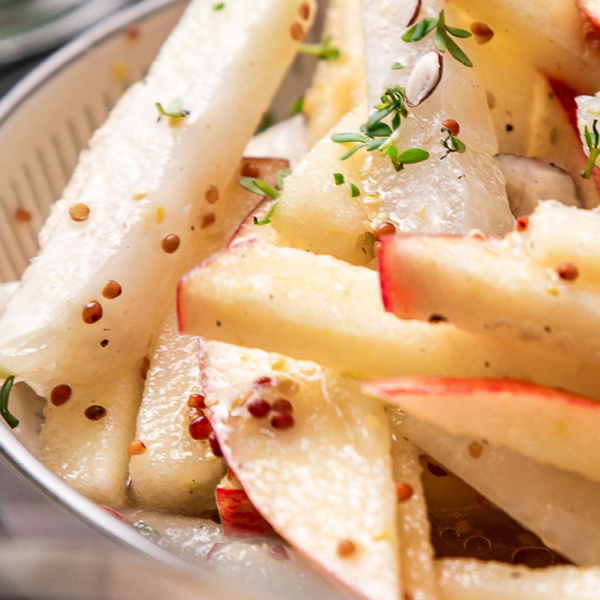 KI generiert: Ein Salat mit Apfel- und Kohlrabistücken, Senfkörnern und frischen Kräutern.