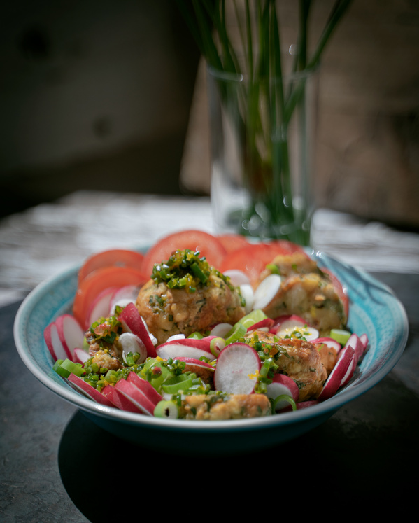 KI generiert: Ein Schüsselgericht mit Gemüse, Knödeln und frischen Kräutern, dekorativ angerichtet.