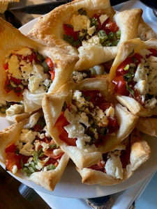 KI generiert: Das Bild zeigt einen gefüllten Wrap, der mit frischem Gemüse und Saucen versehen ist. Der Fokus liegt auf der appetitlichen Nahaufnahme des gefüllten Wraps auf einem dunklen Untergrund.