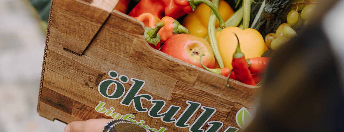 KI generiert: Kiste mit frischem Obst und Gemüse. Text: "ökulli biofrisch".