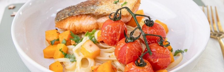 KI generiert: Gelbe Schüssel mit Nudeln, Brokkoli und Kürbissauce auf Holzuntergrund.