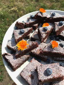 KI generiert: Das Bild zeigt ein Dessert im Glas, das mit einer Löffelportion Croquant und einem Blatt grüne Dekoration versehen ist. Im Hintergrund ist unscharf grüne Dekoration sichtbar.