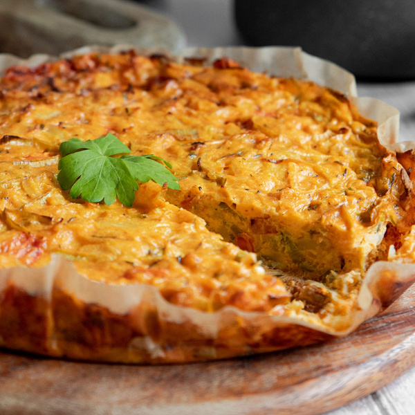 KI generiert: Quiche mit einer Scheibe herausgenommen, dekoriert mit einem grünen Petersilienblatt.