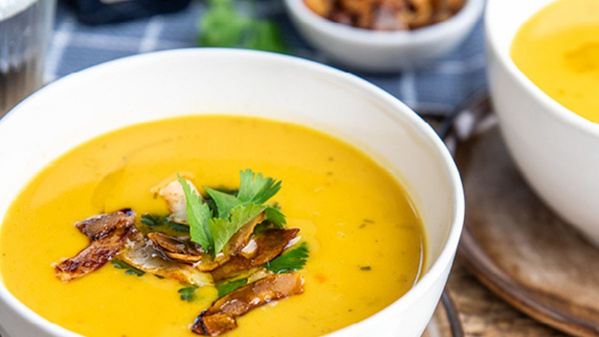 KI generiert: Eine Schüssel Kürbissuppe, garniert mit Kräutern und knusprigen Toppings.