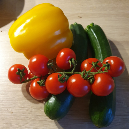 KI generiert: Paprika, Zucchini und Cocktailtomaten auf einem Tisch.