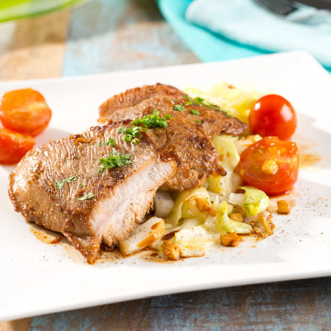 KI generiert: Gegrillter Fisch mit Gemüse und Tomaten auf einem weißen Teller angerichtet.