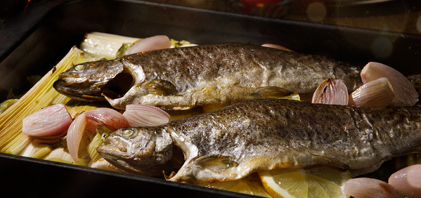KI generiert: Zwei gebackene Fische mit Schalotten und Lauch in einer Auflaufform.