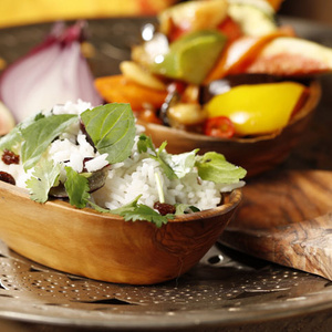 KI generiert: Das Bild zeigt ein Dessert im Glas, das mit einer Löffelportion Croquant und einem Blatt grüne Dekoration versehen ist. Im Hintergrund ist unscharf grüne Dekoration sichtbar.