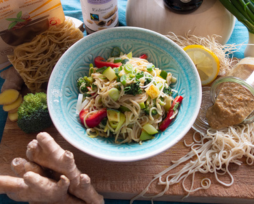KI generiert: Das Bild zeigt ein Dip im Glas, das mit einer Löffelportion Croquant und einem Blatt grüne Dekoration versehen ist. Im Hintergrund ist unscharf grüne Dekoration sichtbar.