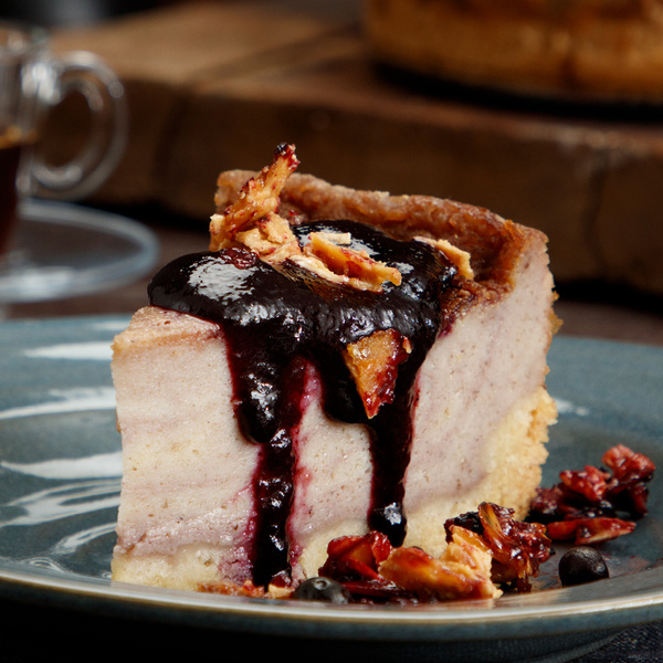 KI generiert: Ein Stück Kuchen mit dunklem Fruchtbelag und knusprigen Toppings auf einem Teller.