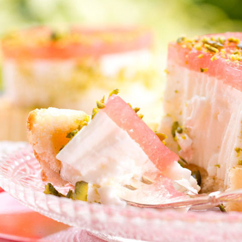 KI generiert: Ein Stück Torte mit weißer Creme und rosa Gelee, bestreut mit Pistazien.