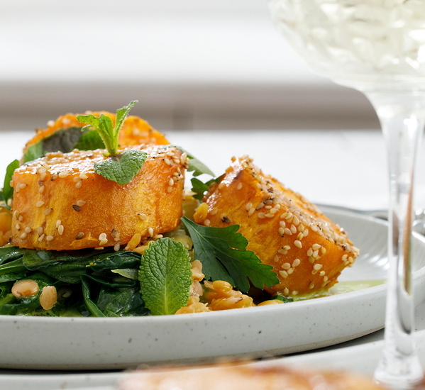 KI generiert: Gericht aus Sesam-Tofu, serviert auf Spinat und Garnitur mit frischen Kräutern.