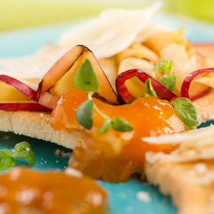 KI generiert: Das Bild zeigt ein Dessert im Glas, das mit einer Löffelportion Croquant und einem Blatt grüne Dekoration versehen ist. Im Hintergrund ist unscharf grüne Dekoration sichtbar.