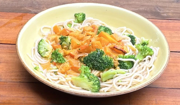 KI generiert: Ein Teller mit Nudeln, Brokkoli und einer Sauce mit Karottenstücken.