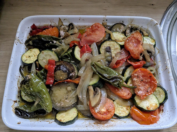 KI generiert: Ein Auflauf mit gebackenem Gemüse wie Zucchini, Tomaten und Paprika in einer weißen Auflaufform.