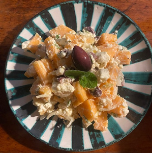 KI generiert: Das Bild zeigt einen in zwei Hälften geschnittenen Butternut-Kürbis auf einem Holzschneidebrett mit herzförmiger Aussparung. Der Kürbis ist leuchtend orange und hat sichtbare Kerne.