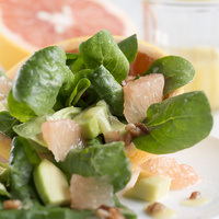 KI generiert: Ein frischer Salat mit Spinat, Grapefruit und Avocado auf einem Teller.