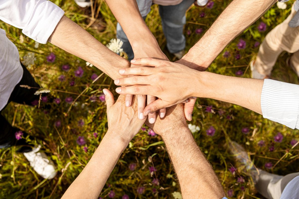 KI generiert: Mehrere Hände, die sich in der Mitte überlappen, Symbol für Gemeinschaft und Zusammenhalt.