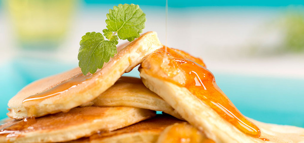 KI generiert: Pfannkuchen mit Sirup und Minze garniert.
