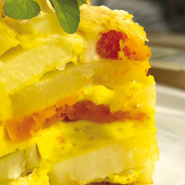 KI generiert: Nahaufnahme eines bunten, geschichteten Auflaufs mit Kräutergarnitur.