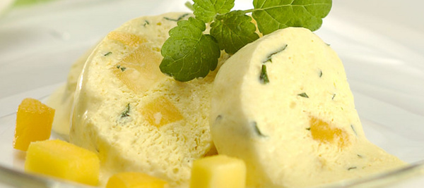 KI generiert: Eiskalter Nachtisch mit Fruchtstücken und Minzblatt, serviert auf einem Teller.