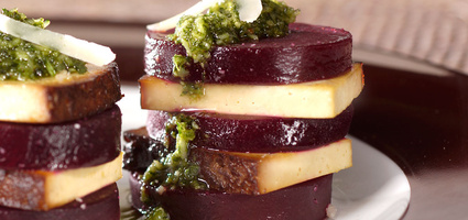 KI generiert: Scheiben von Roter Beete und Käse, gestapelt, mit grünem Pesto garniert.