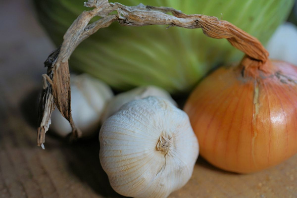 KI generiert: Knoblauch, Zwiebel und Kohl auf einem Holztisch.