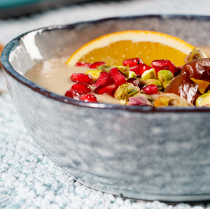 KI generiert: Ein Glas Schokoladenmousse, garniert mit Beeren und Minze, auf einem rustikalen Holztisch.