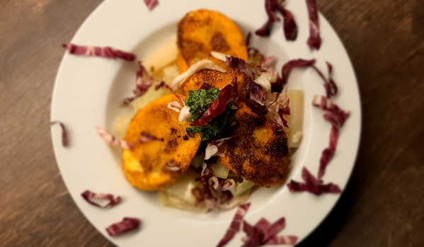 KI generiert: Ein Tellergericht mit gebratenem Gemüse und Kräutern, garniert mit roten und grünen Salatstreifen.