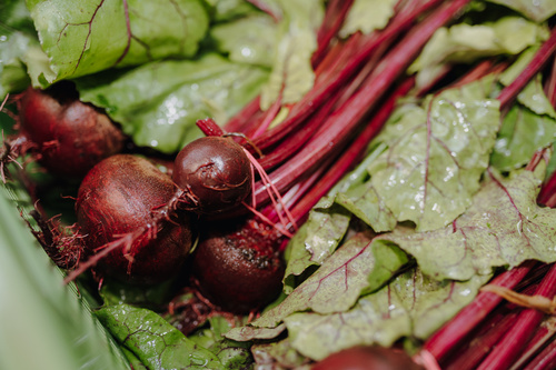 KI generiert: Frische Rote Bete mit Blättern, nah aufgenommen.