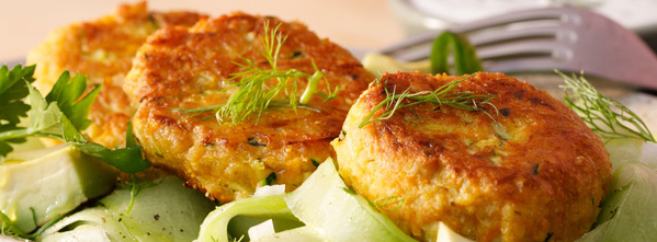 KI generiert: Drei Gemüsefrikadellen auf Gurkensalat, garniert mit frischen Kräutern.