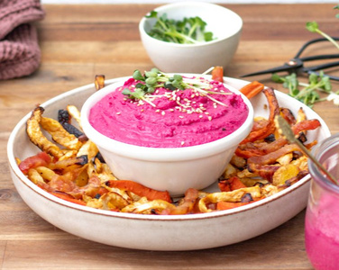 KI generiert: Das Bild zeigt ein Dip im Glas, das mit einer Löffelportion Croquant und einem Blatt grüne Dekoration versehen ist. Im Hintergrund ist unscharf grüne Dekoration sichtbar.