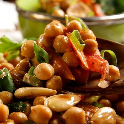 KI generiert: Ein Teller mit Kichererbsensalat, verziert mit Paprika, Mandeln und Kräutern.