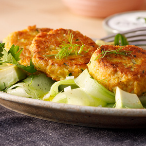 KI generiert: Das Bild zeigt ein Dessert im Glas, das mit einer Löffelportion Croquant und einem Blatt grüne Dekoration versehen ist. Im Hintergrund ist unscharf grüne Dekoration sichtbar.